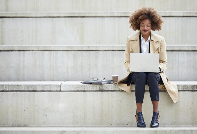 young businesswoman using laptop on steps