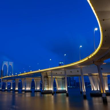 bridge over water with lights on outer edge of bridge