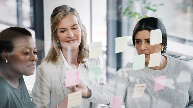 Woman is sticking something on the mirror