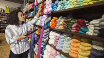 Woman choosing cotton yarn in shop