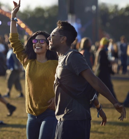 Friends dancing at festival with arms in air