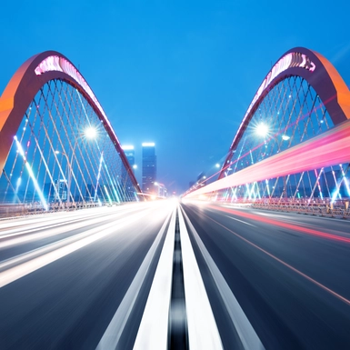 bridge at night with lights in motion