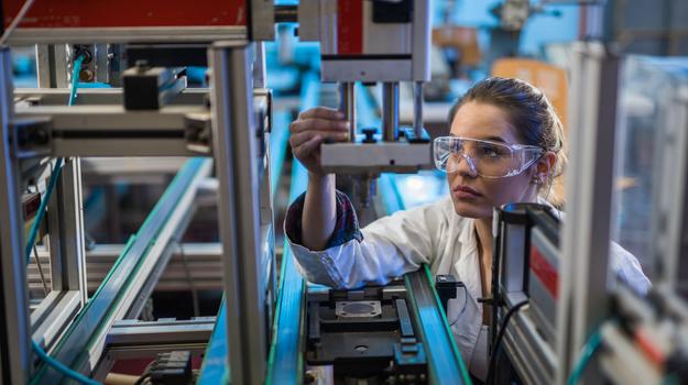 quality control worker analyzing machine part