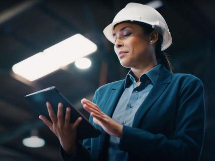 woman in hard hat looking at tablet