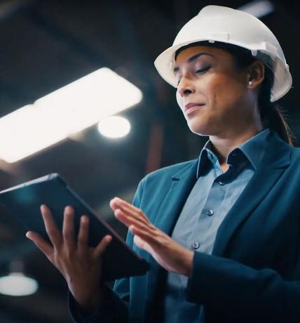 woman in hard hat looking at tablet