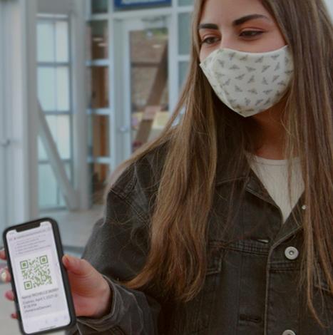 College student with mask showing phone app