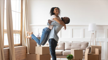 couple happily hugging in room full of boxes