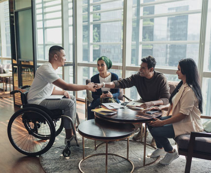 man in wheelchair meeting with group of people