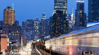 city at night with moving trains and headlights