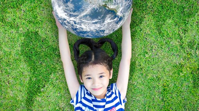 Girl holding a globe on the grass