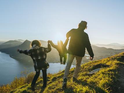 family holding hands walking on top of hill