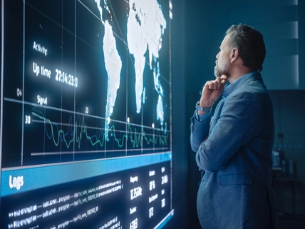 man looking pensively at a data screen