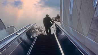 man going up escalator 