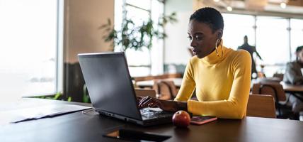 woman working at laptop with apple