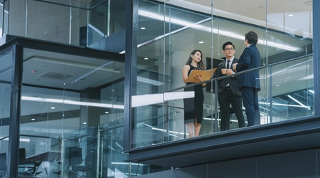 people meeting outside of glass office windows