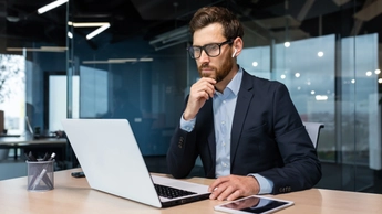 man in conference room looking at laptop