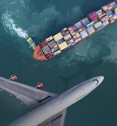Airplane flying over cargo ship in water