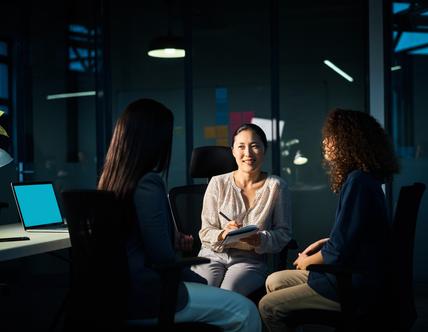 Businesswoman meeting with colleagues in an office in the evening