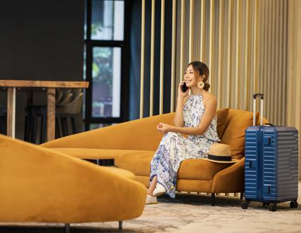 Young Tourist Women on phone call by sitting on sofa at hotel lounge , entrance hall