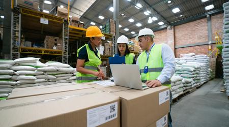 Group of Latin American workers working together at a distribution warehouse and planning some shipments
