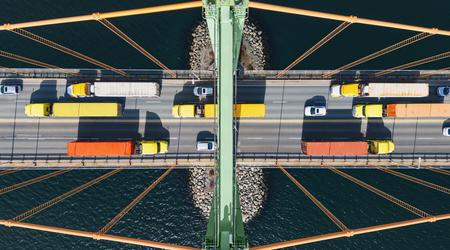 Aerial view of semi trucks crossing a suspension bridge
