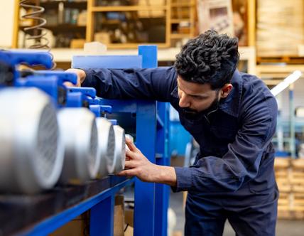Indian employee working at a manufacturing factory assembling water pumps - production line concepts